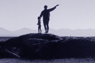 woman and child celebrate on rocks